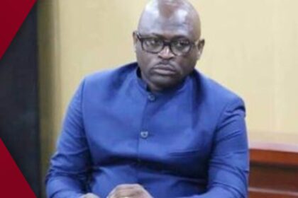 4:5 vertical shot showing a glowing city skyline silhouetted against a warm orange and pink sunset, captured via WhatsApp